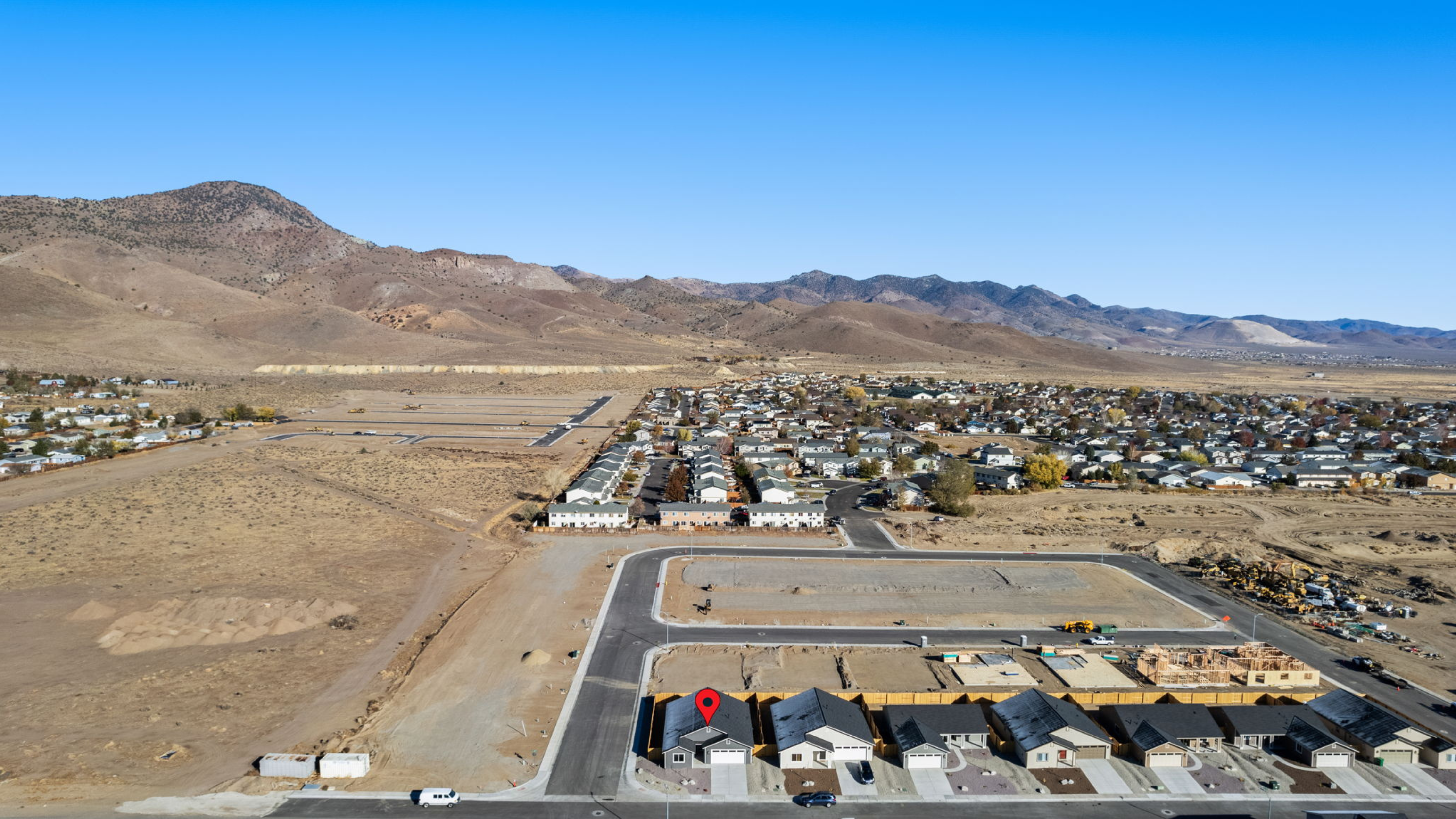 Aerial view of GC Phase 3 Manor Apartments under construction with mountains in the background.